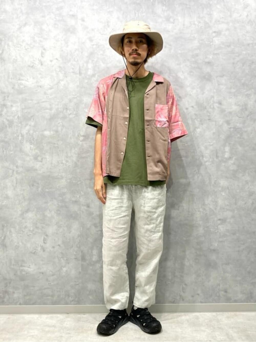 ベージュ系のシャツ/ブラウス、グリーン系のTシャツ/カットソー、ホワイト系のスラックスを着用したメンズの夏コーディネートの1枚目の写真