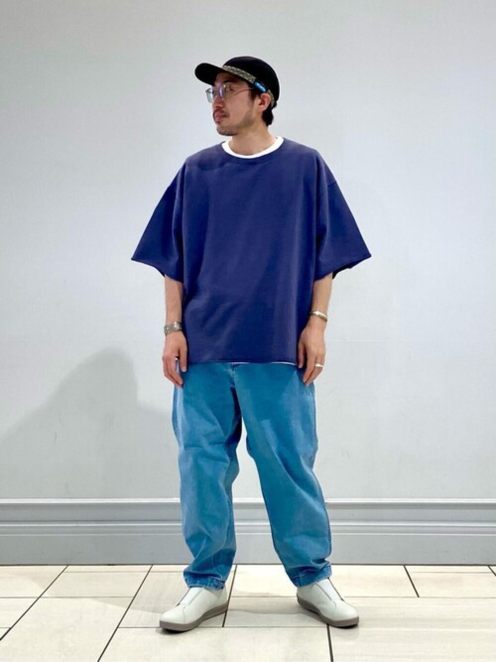 グレー系のTシャツ/カットソー、ブルー系のデニムパンツ、グレー系のスニーカーを着用したメンズの夏コーディネートの1枚目の写真