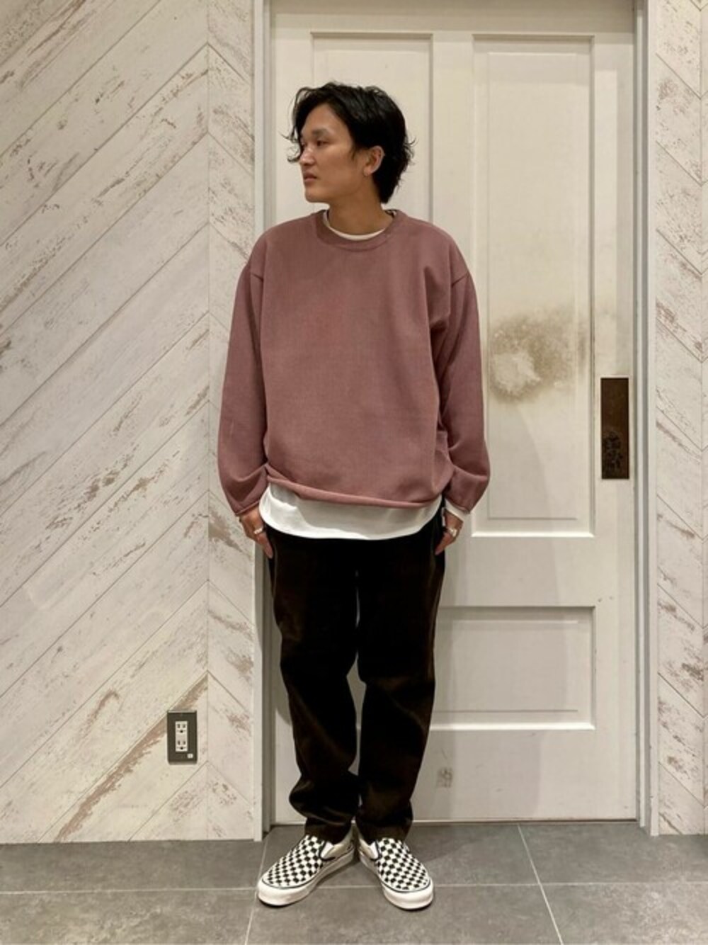 ピンク系のニット/セーター、ブラウン系のその他パンツ、ブラック系のスリッポンを着用したメンズの秋コーディネートの1枚目の写真