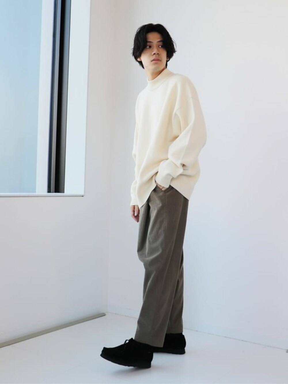 ベージュ系のニット/セーター、グリーン系のその他パンツ、ブラック系のスニーカーを着用したメンズの秋コーディネートの1枚目の写真