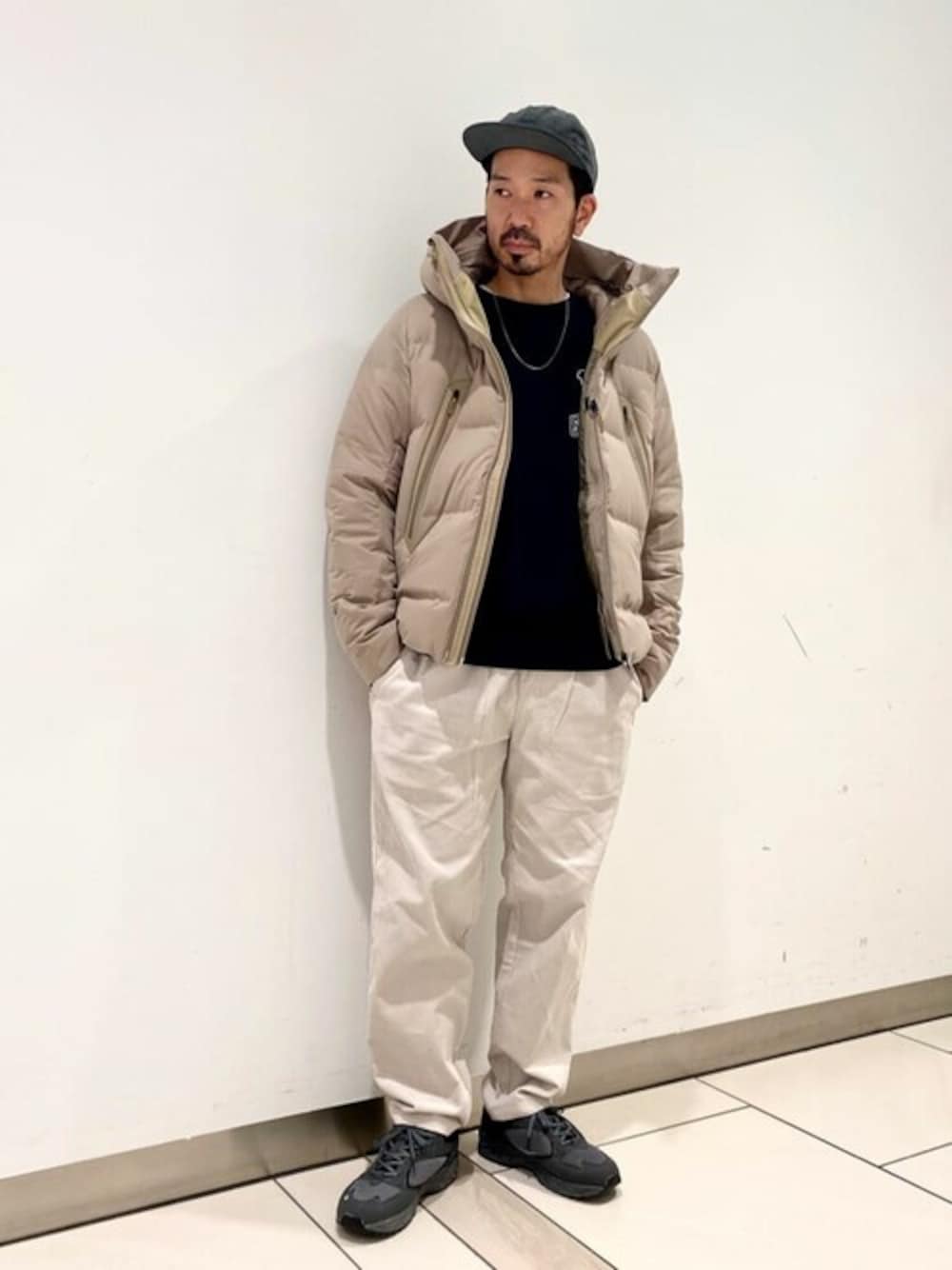 ベージュ系のダウンジャケット/コート、ブラック系のスウェット、グレー系のチノパンツを着用したメンズの秋コーディネートの1枚目の写真