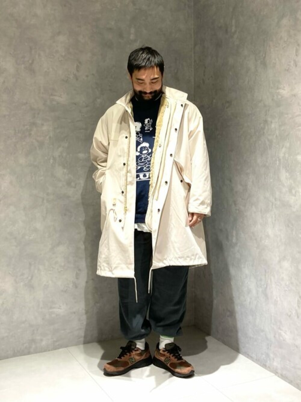 ベージュ系のモッズコート、ブルー系のスウェット、ブラック系のその他パンツを着用したメンズの冬コーディネートの1枚目の写真