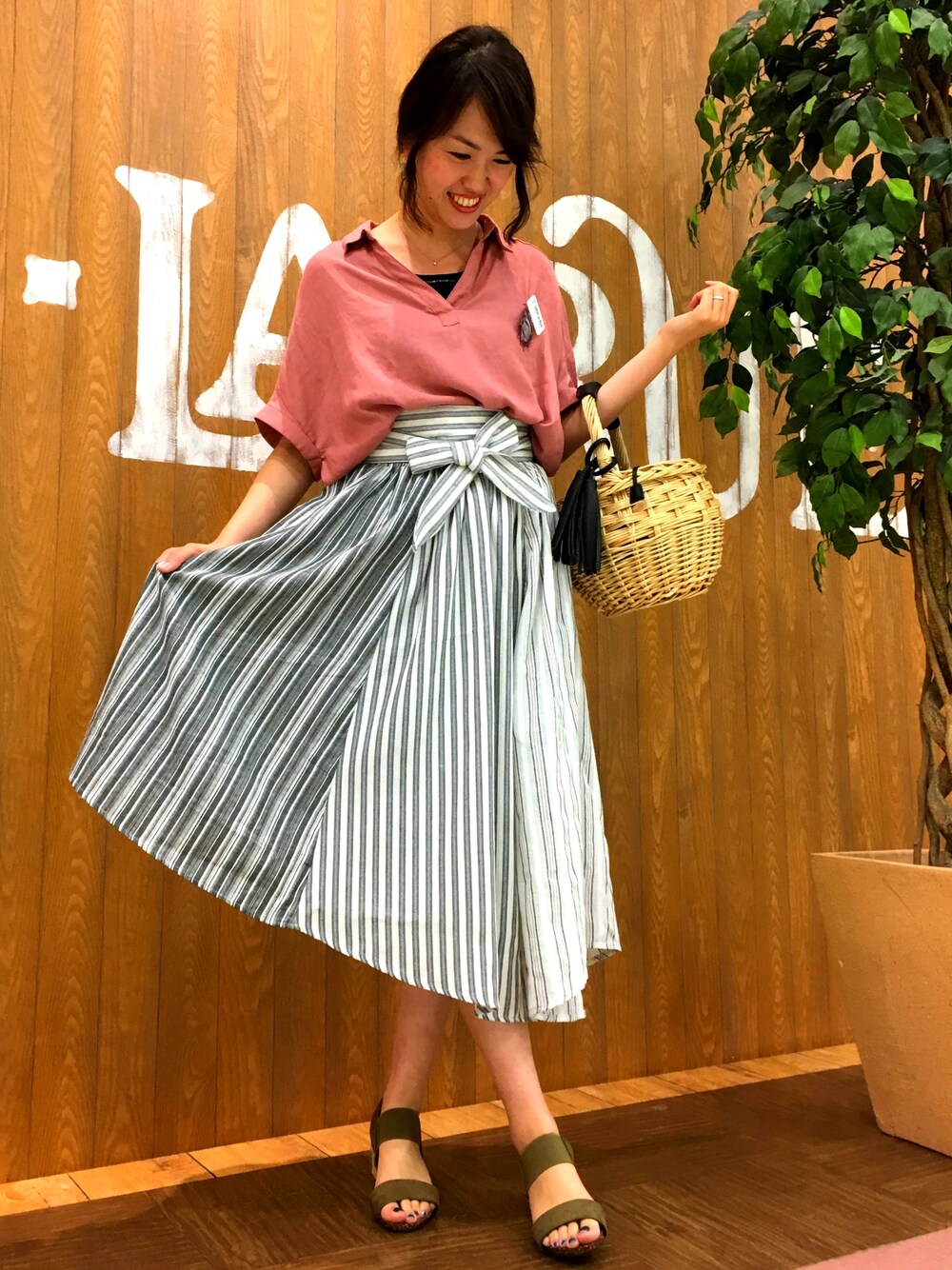 ピンク系のシャツ/ブラウス、ブラック系のスカート、グリーン系のサンダルを着用したレディースの夏コーディネートの1枚目の写真