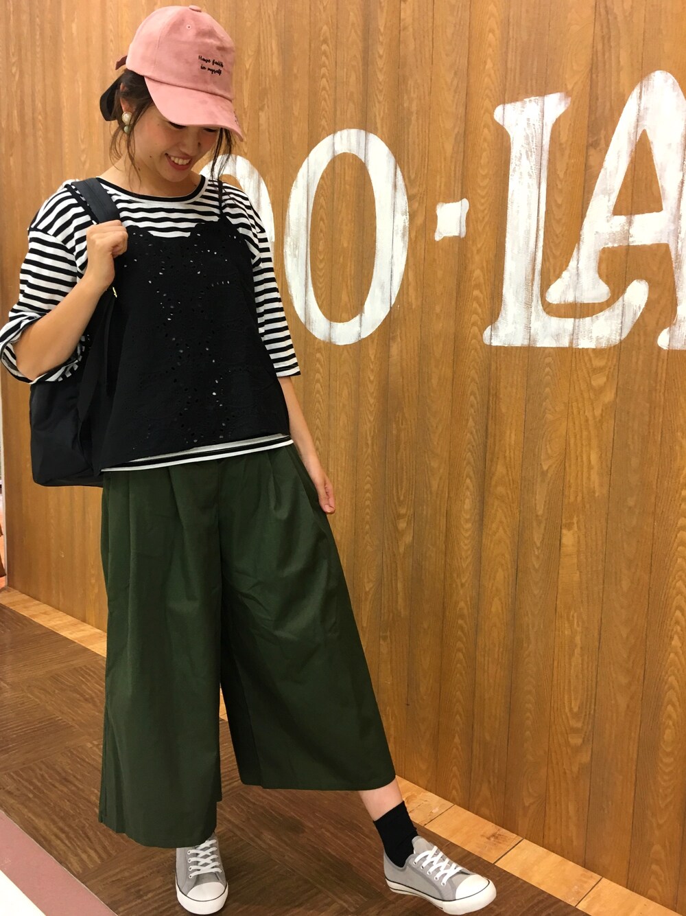 ブラック系のTシャツ/カットソー、グリーン系のパンツ、グレー系のスニーカーを着用したレディースの秋コーディネートの1枚目の写真