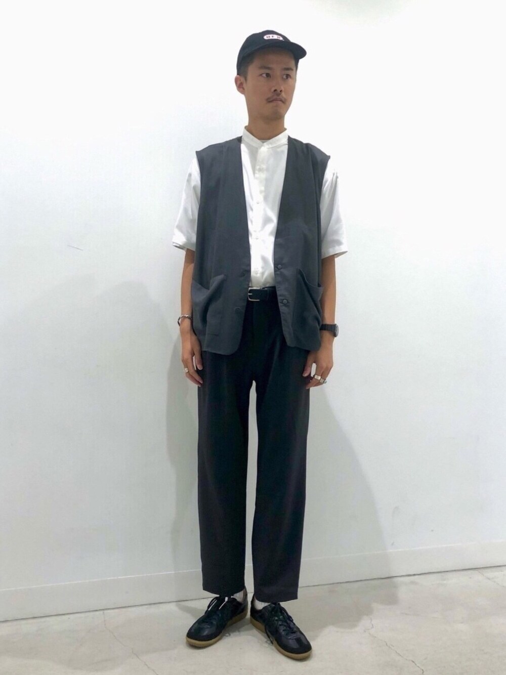 ホワイト系のシャツ/ブラウス、グレー系のスラックス、ブラック系のスニーカーを着用したメンズの春コーディネートの1枚目の写真