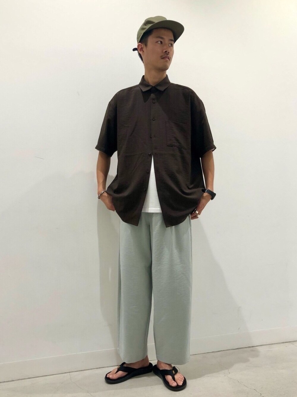 ブラウン系のシャツ/ブラウス、グリーン系のその他パンツ、ブラック系のサンダルを着用したメンズの春コーディネートの1枚目の写真