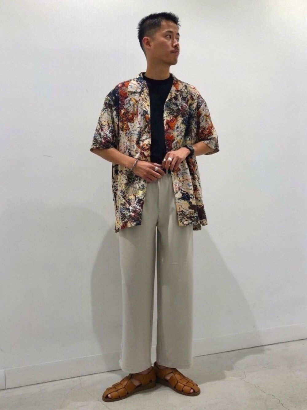 ベージュ系のスラックス、ブラック系のTシャツ/カットソーを着用したメンズの春コーディネートの1枚目の写真