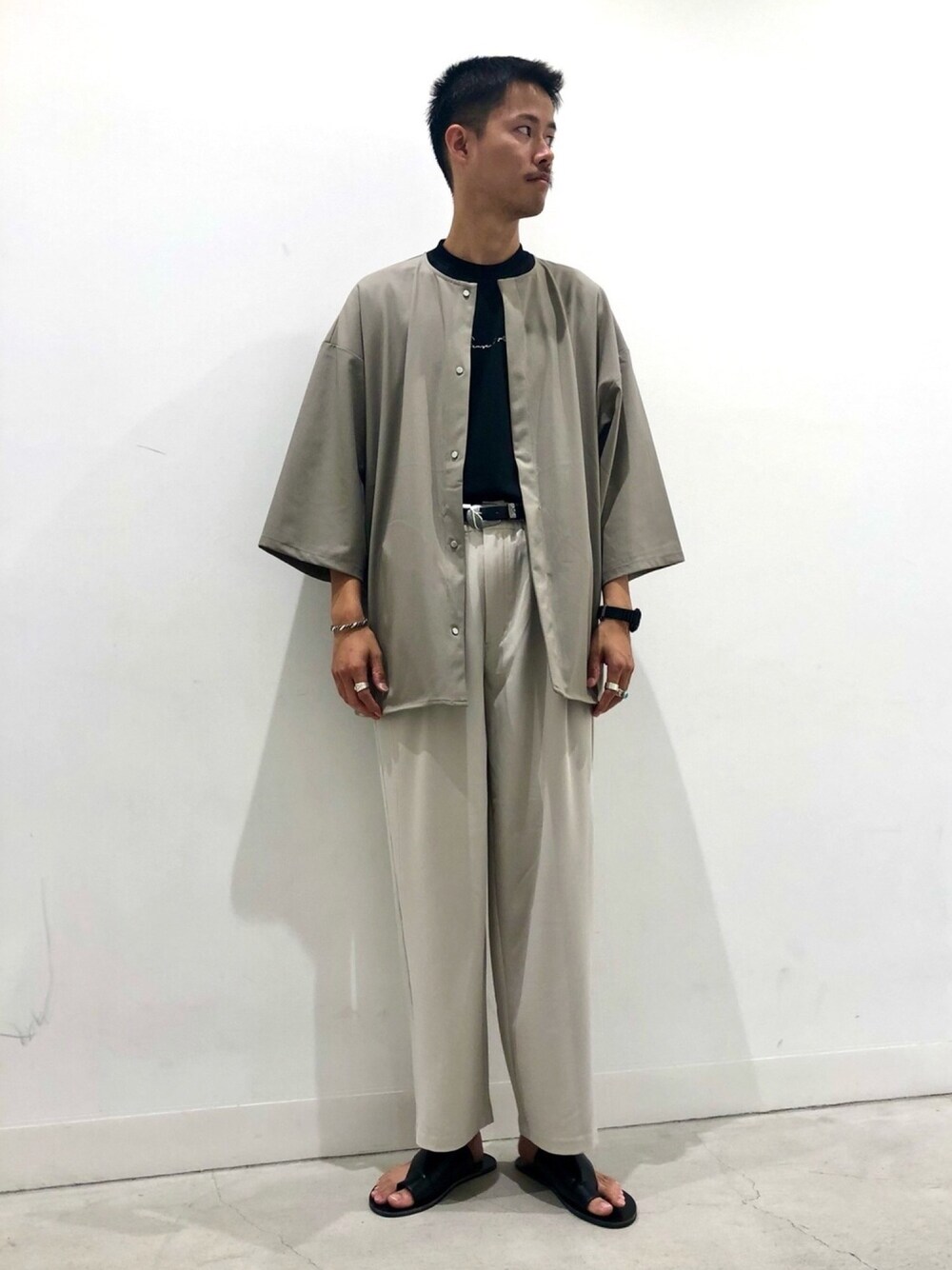 ベージュ系のシャツ/ブラウス、ベージュ系のスラックス、ブラック系のサンダルを着用したメンズの夏コーディネートの1枚目の写真