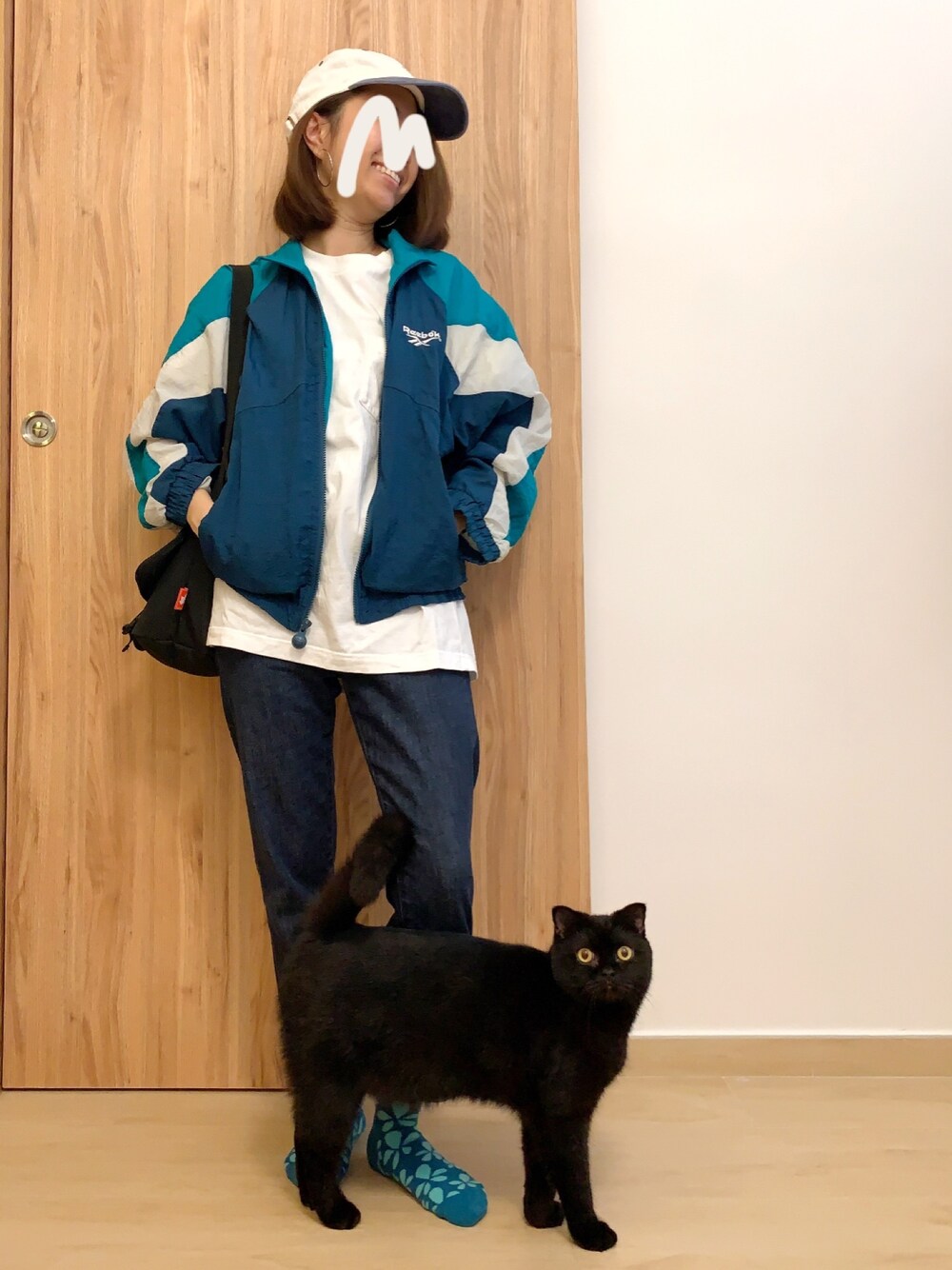 グリーン系のナイロンジャケット、グリーン系のナイロンジャケット、ブルー系のデニムパンツを着用したレディースの冬コーディネートの1枚目の写真