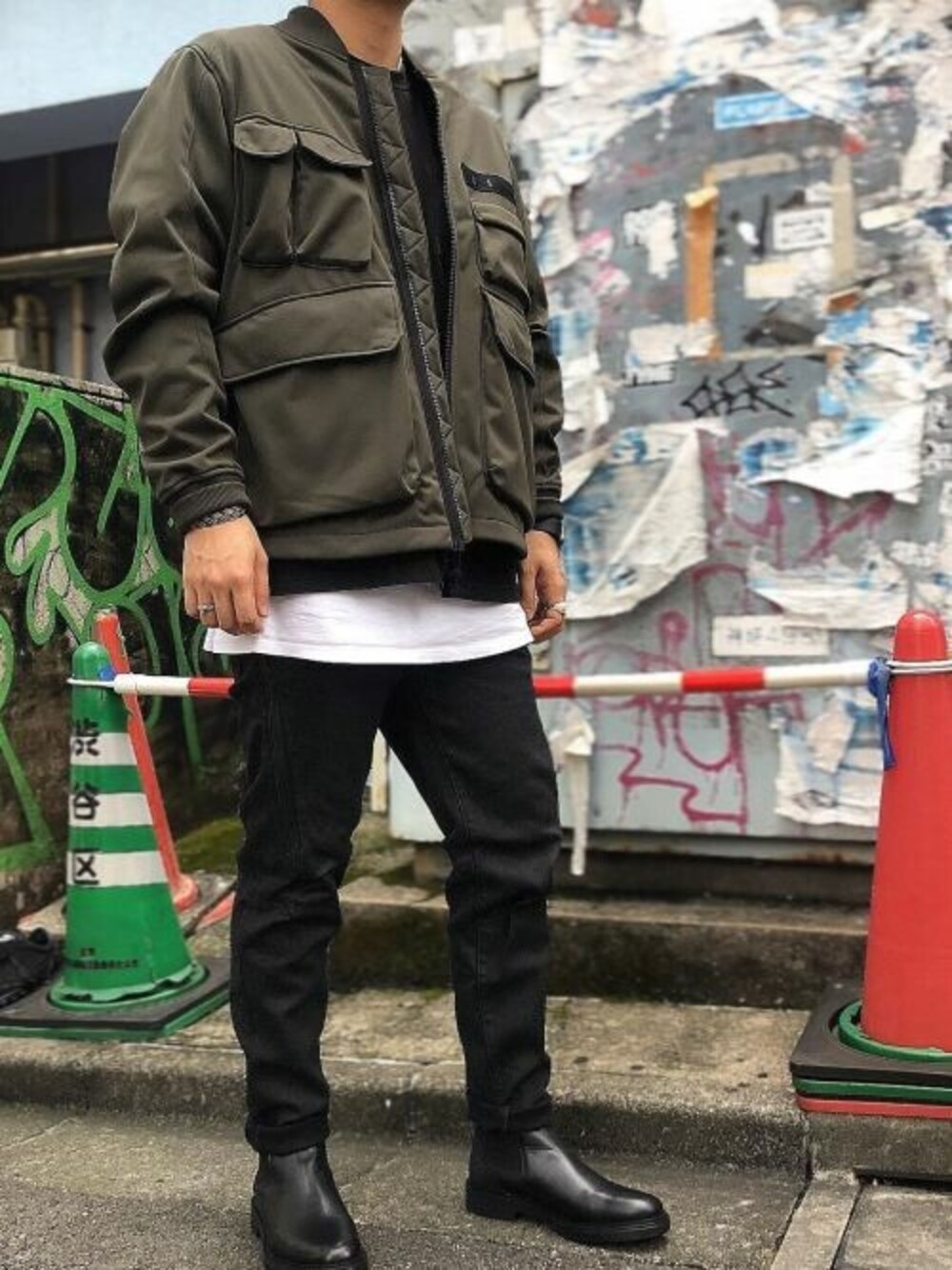 グリーン系のミリタリージャケット、ブラック系のデニムパンツを着用したメンズの秋コーディネートの1枚目の写真