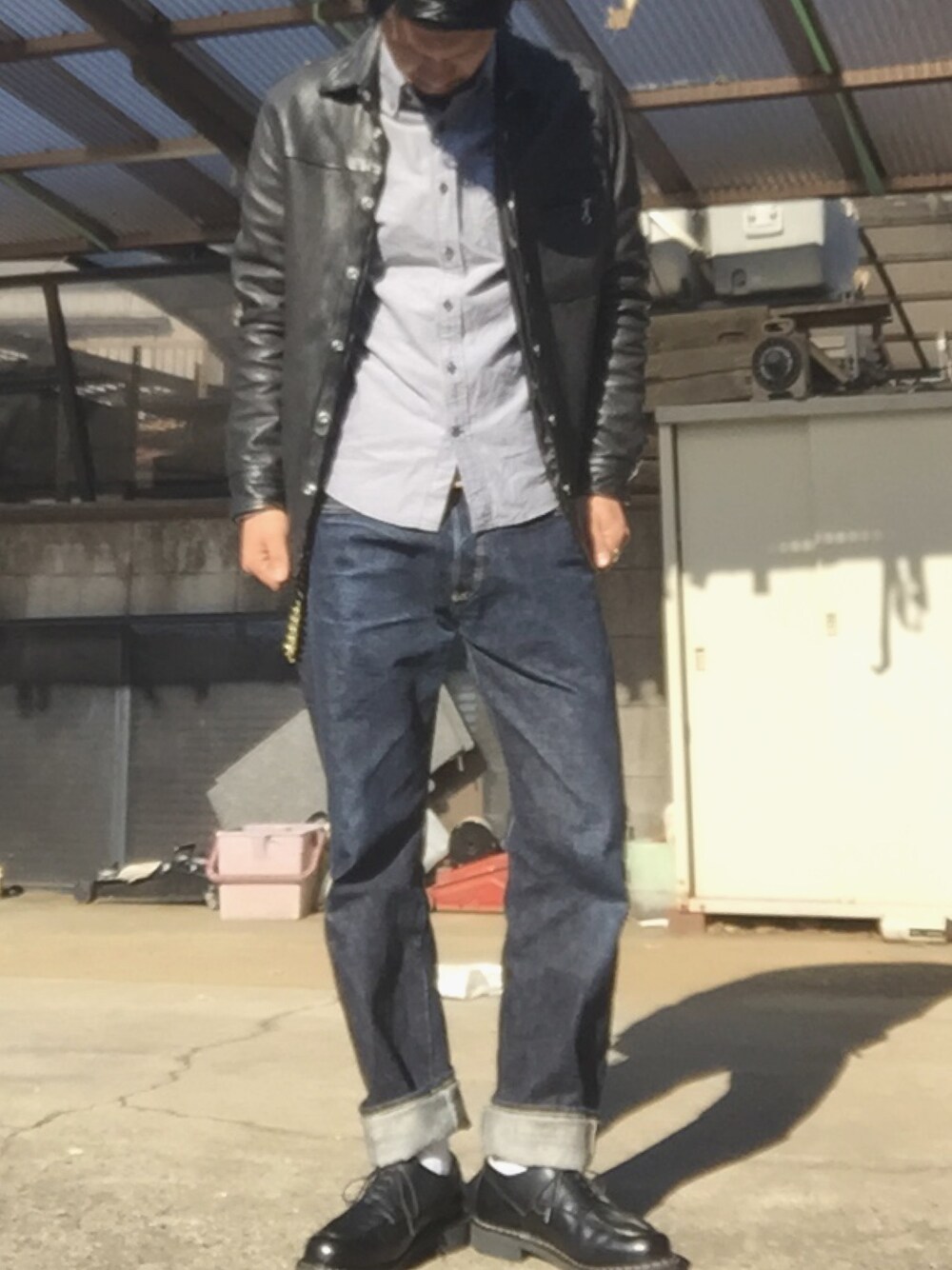 グレー系のシャツ/ブラウス、ブラック系のライダースジャケット、ブルー系のデニムパンツを着用したメンズの秋コーディネートの1枚目の写真