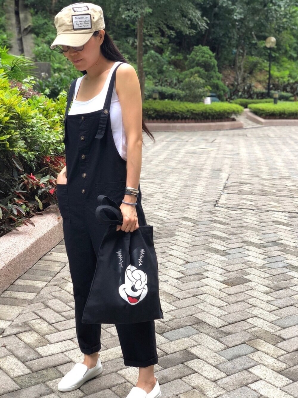 ホワイト系のトップス、ブラック系のサロペット/オーバーオール、ブラック系のエコバッグ/サブバッグを着用したレディースの夏コーディネートの1枚目の写真