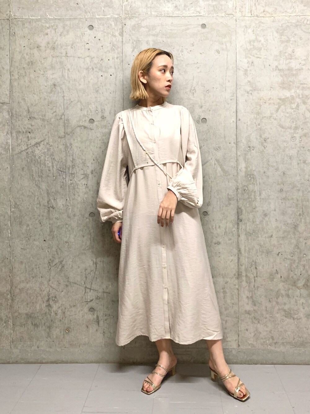 ホワイト系のワンピース、ゴールド系のサンダル、ホワイト系のネックレスを着用したレディースの春コーディネートの1枚目の写真