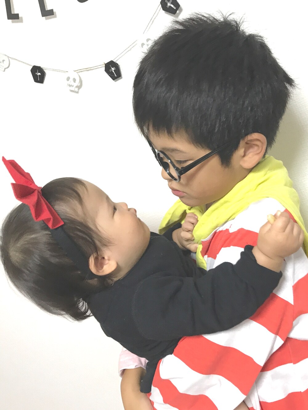 ブラック系のワンピース、ブラック系のスウェット、ブルー系のデニムパンツを着用したキッズの秋コーディネートの1枚目の写真