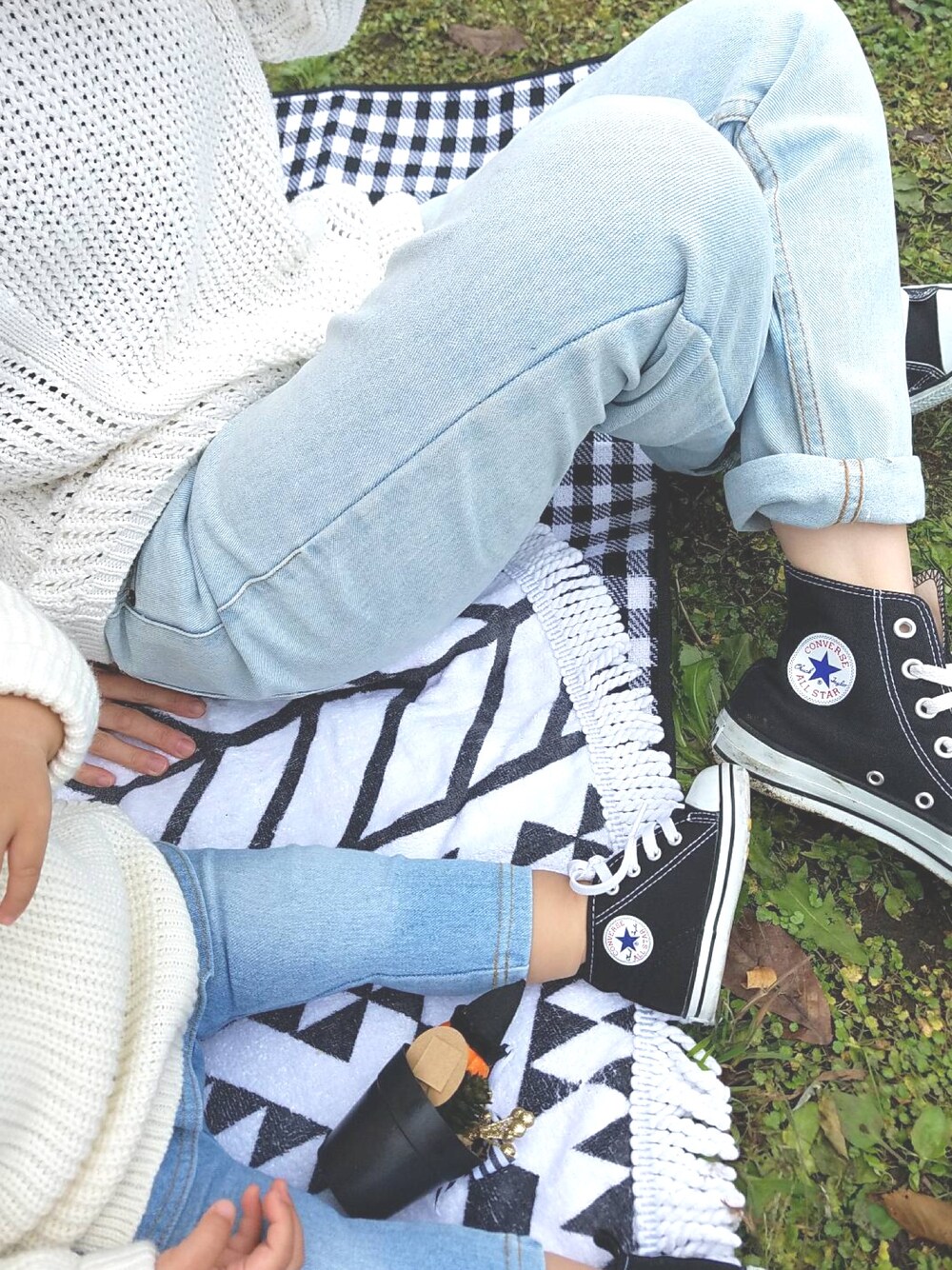 ホワイト系のニット/セーター、ブルー系のデニムパンツ、ブラック系のスニーカーを着用したキッズの秋コーディネートの1枚目の写真