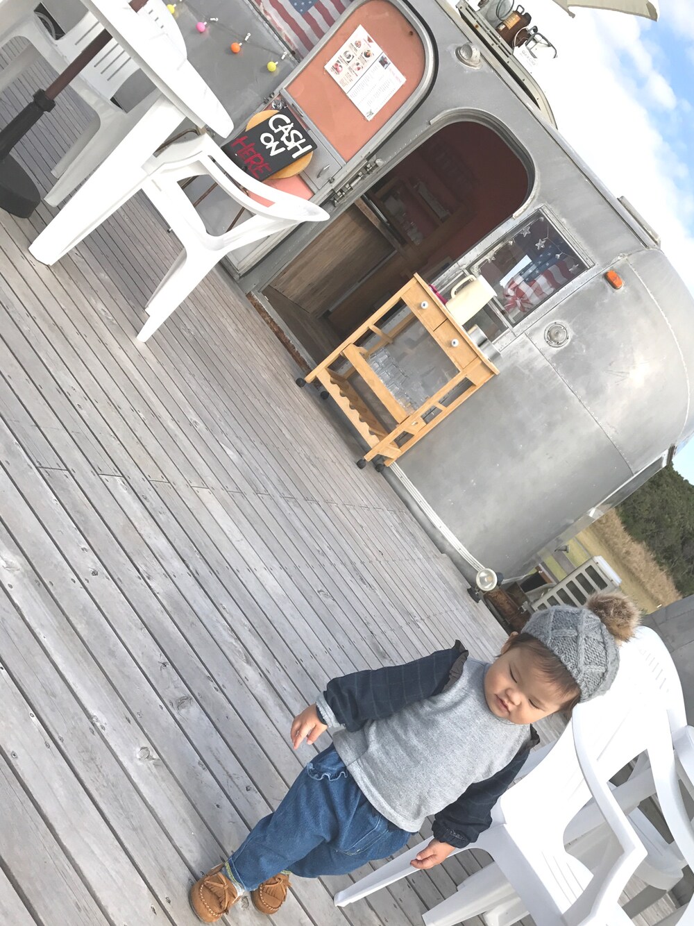 ブラウン系のモカシン/デッキシューズ、ブルー系のパンツ、グレー系のトップスを着用したキッズの秋コーディネートの1枚目の写真