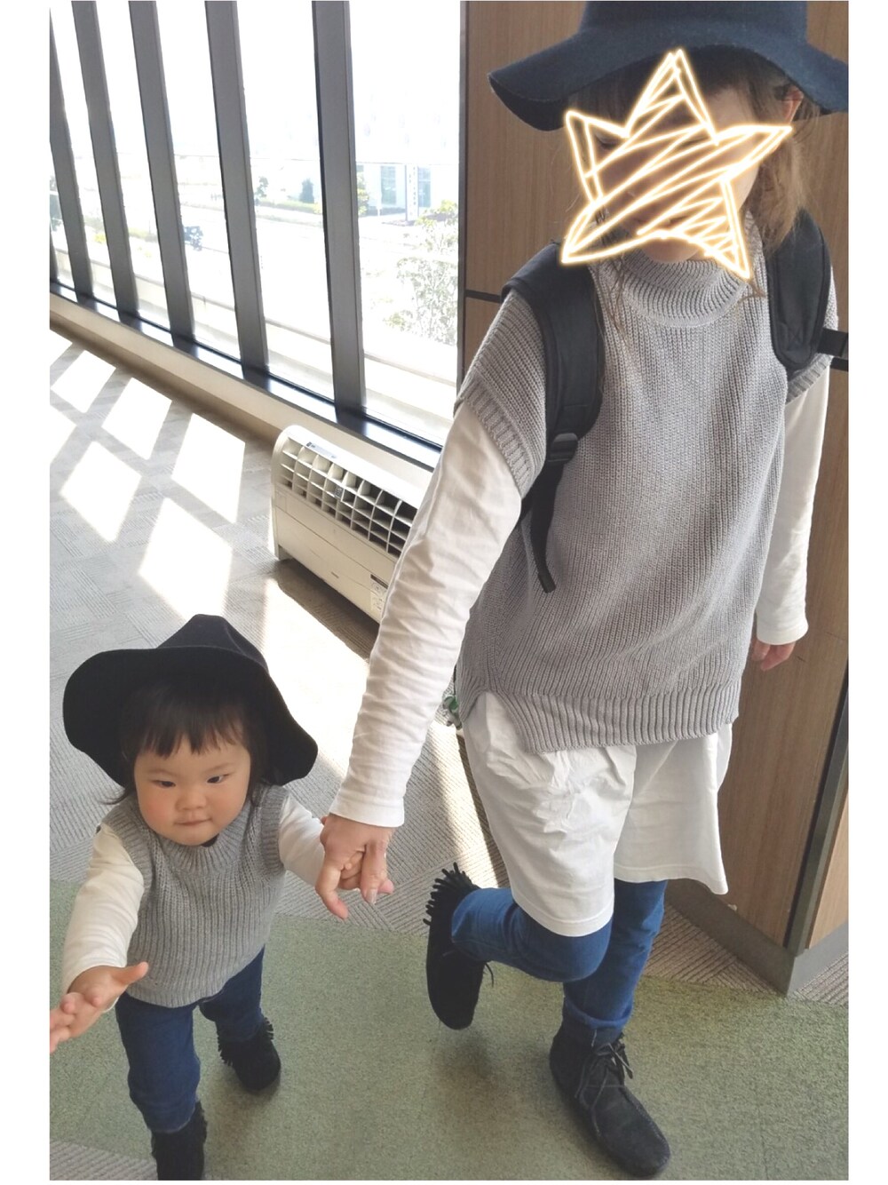 グレー系のベスト、ブラック系のトップス、ブラック系のブーツを着用したキッズの春コーディネートの1枚目の写真