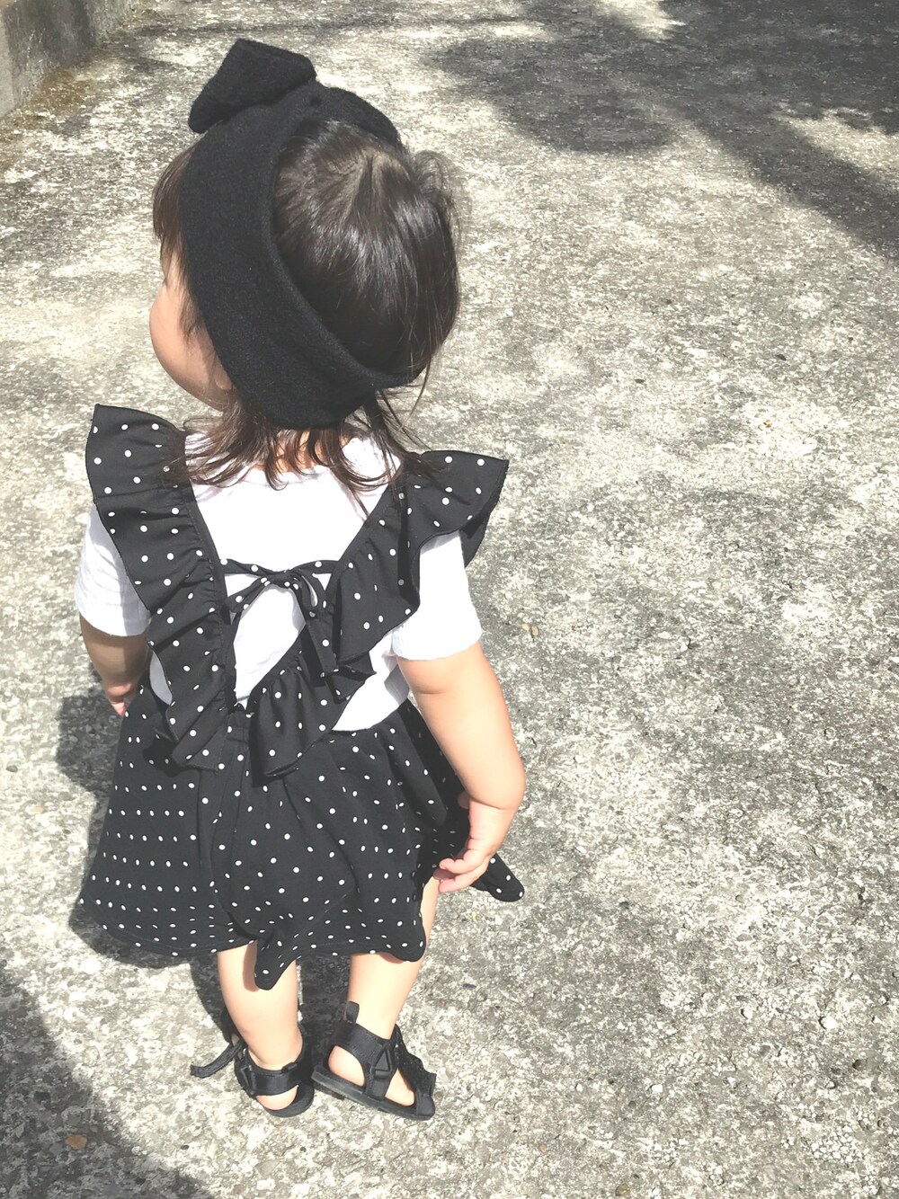 ブラック系のサンダル、ブラック系のその他パンツ、ホワイト系のTシャツ/カットソーを着用したキッズの夏コーディネートの1枚目の写真