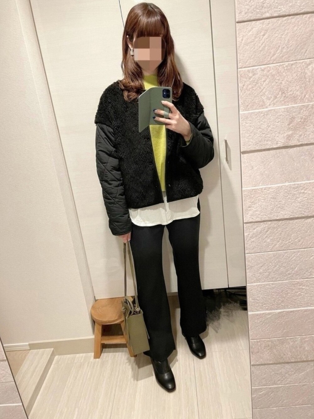 グリーン系のニット/セーター、ブラック系のブルゾン、ホワイト系のTシャツ/カットソーを着用したレディースの冬コーディネートの1枚目の写真