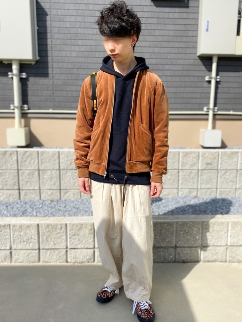 ブラウン系のブルゾン、イエロー系のスニーカー、ベージュ系のパンツを着用したメンズの春コーディネートの1枚目の写真
