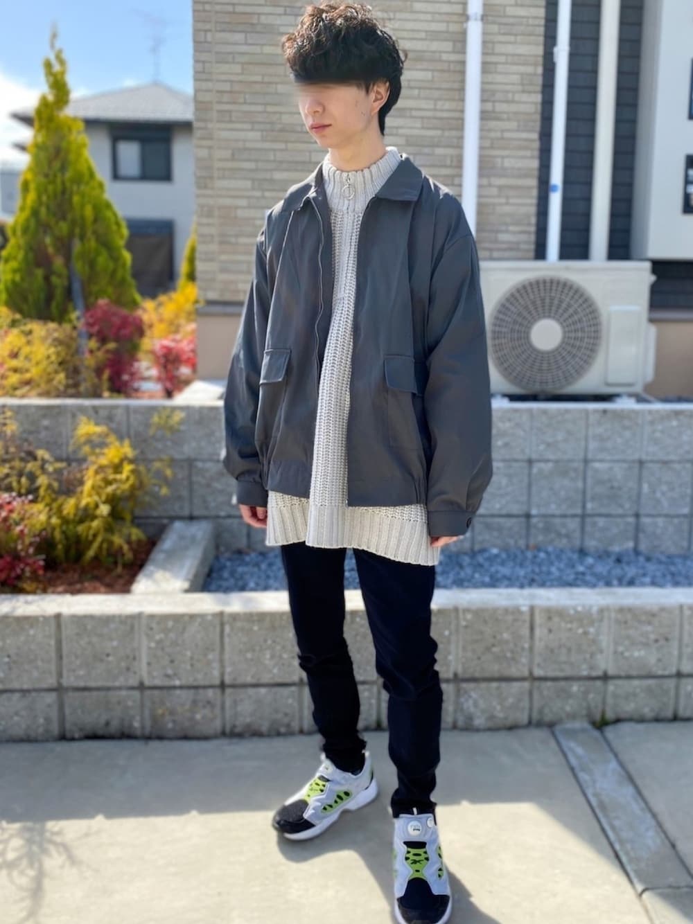 ホワイト系のニット/セーター、グレー系のブルゾン、ブラック系のデニムパンツを着用したメンズの春コーディネートの1枚目の写真