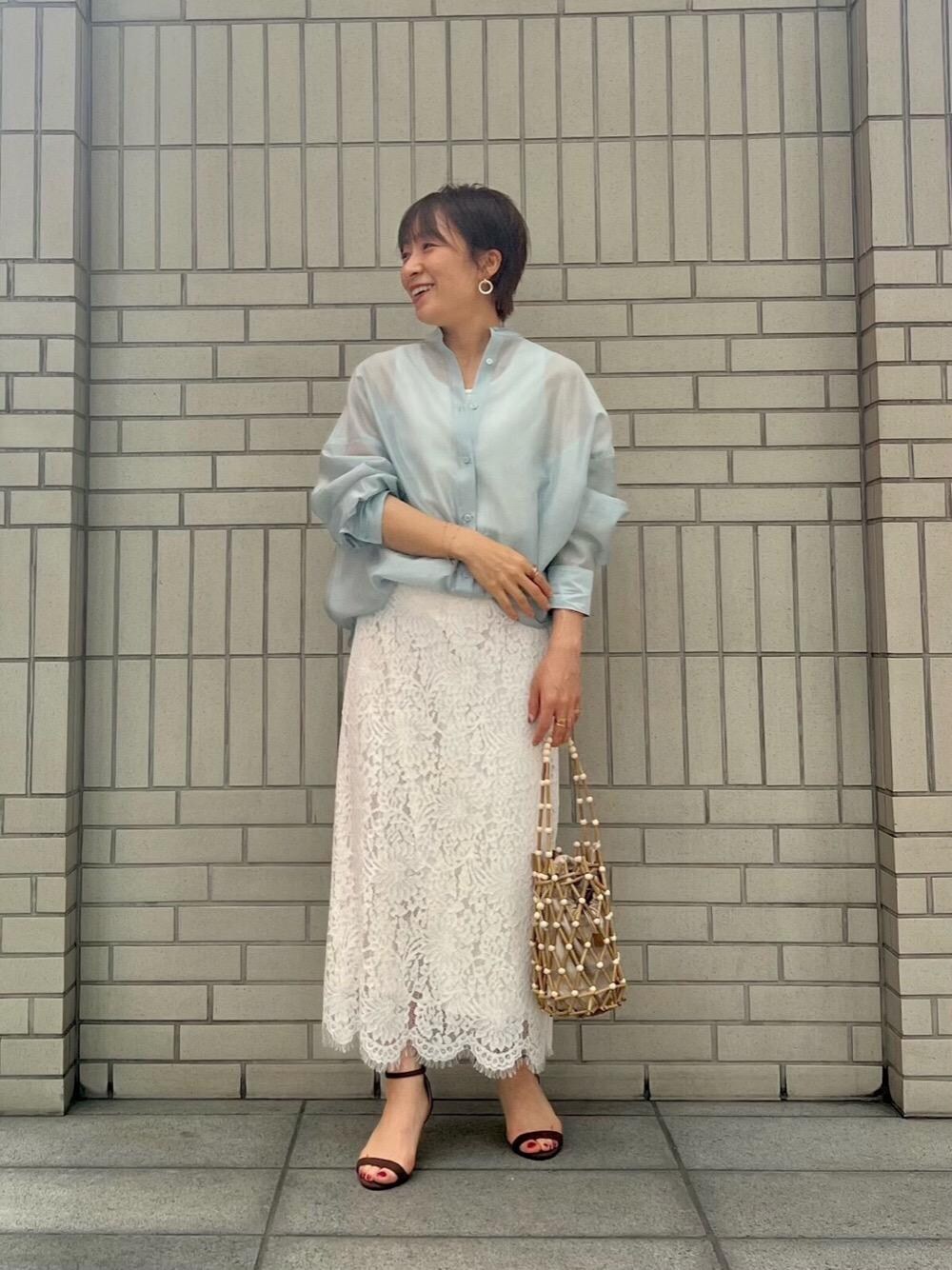 ホワイト系のかごバッグ、ホワイト系のタンクトップ、ブルー系のシャツ/ブラウスを着用したレディースの春コーディネートの1枚目の写真