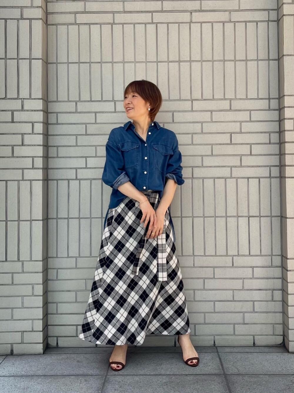 ブルー系のシャツ/ブラウス、ブラック系のスカートを着用したレディースの春コーディネートの1枚目の写真