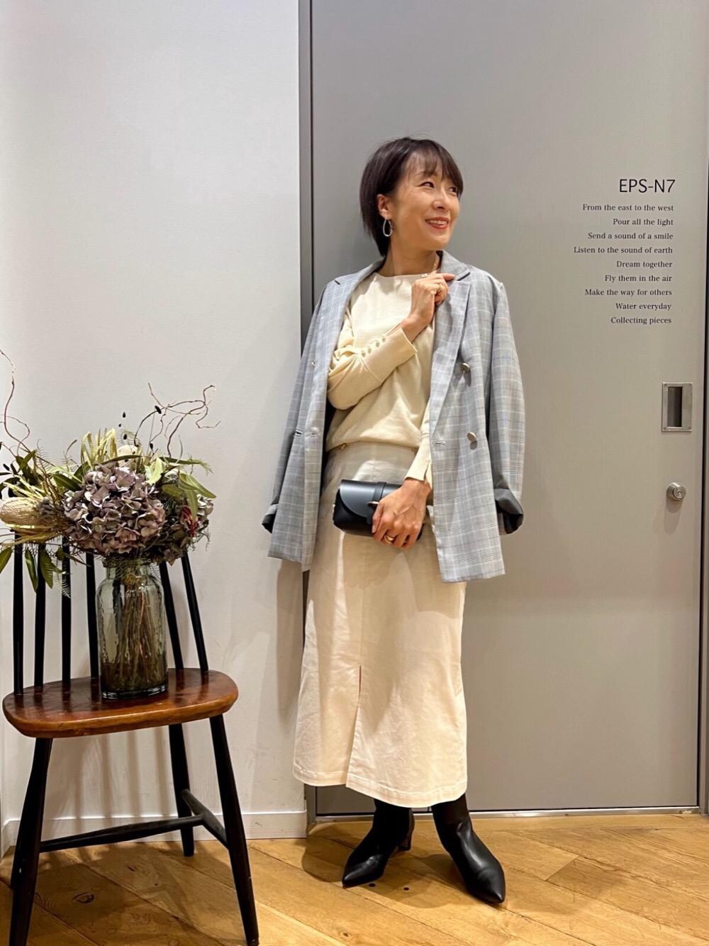 ブラック系のテーラードジャケット、ホワイト系のニット/セーター、ブラック系のショルダーバッグを着用したレディースの秋コーディネートの1枚目の写真