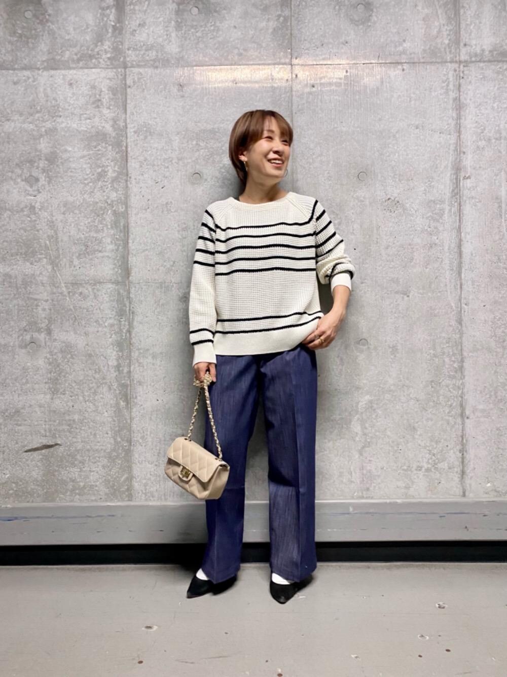 ブルー系のその他パンツ、ホワイト系のニット/セーター、ベージュ系のショルダーバッグを着用したレディースの冬コーディネートの1枚目の写真