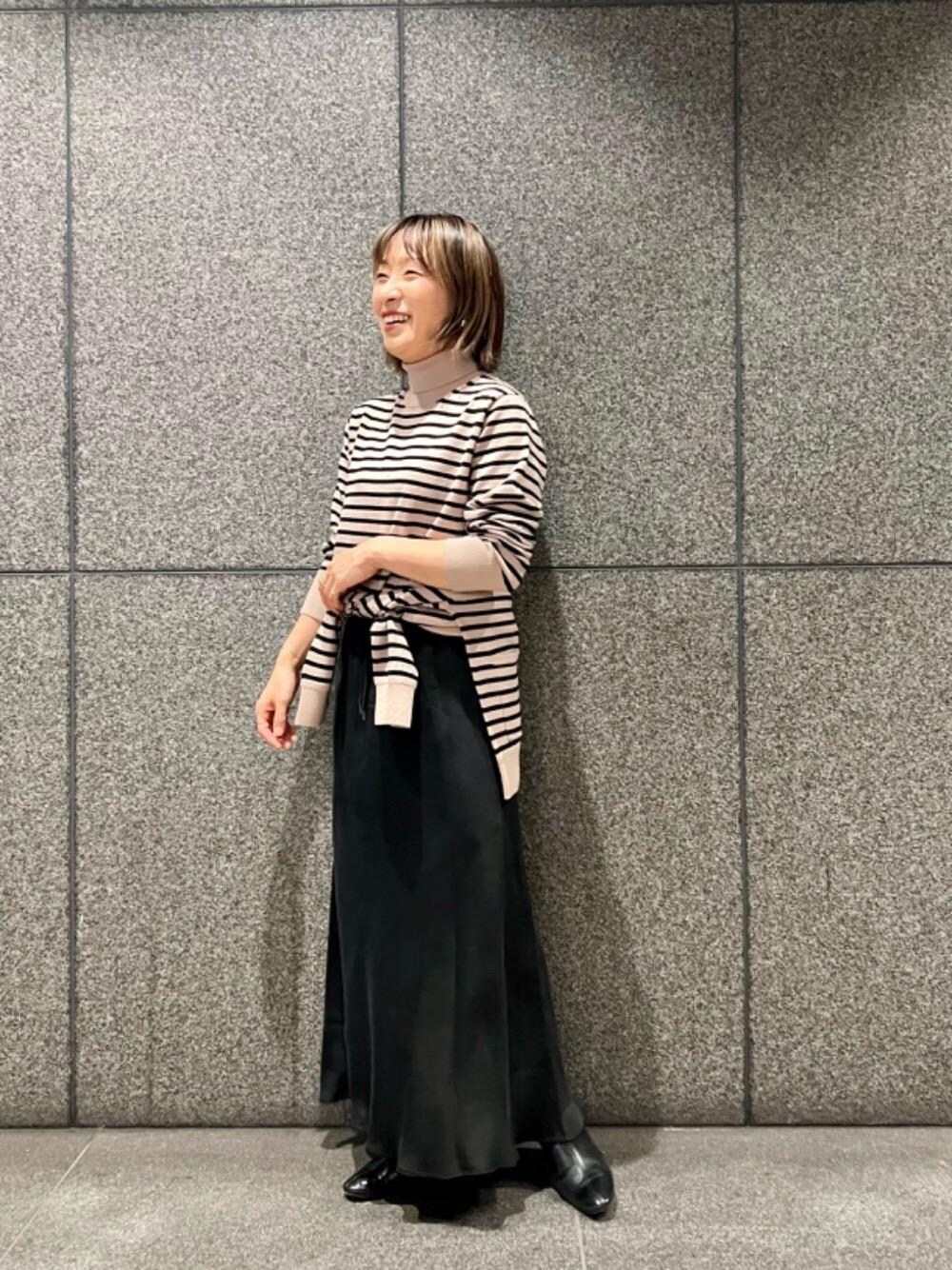 ブラック系のスカート、ブラック系のニット/セーター、ブラック系のカーディガン/ボレロを着用したレディースの秋コーディネートの1枚目の写真