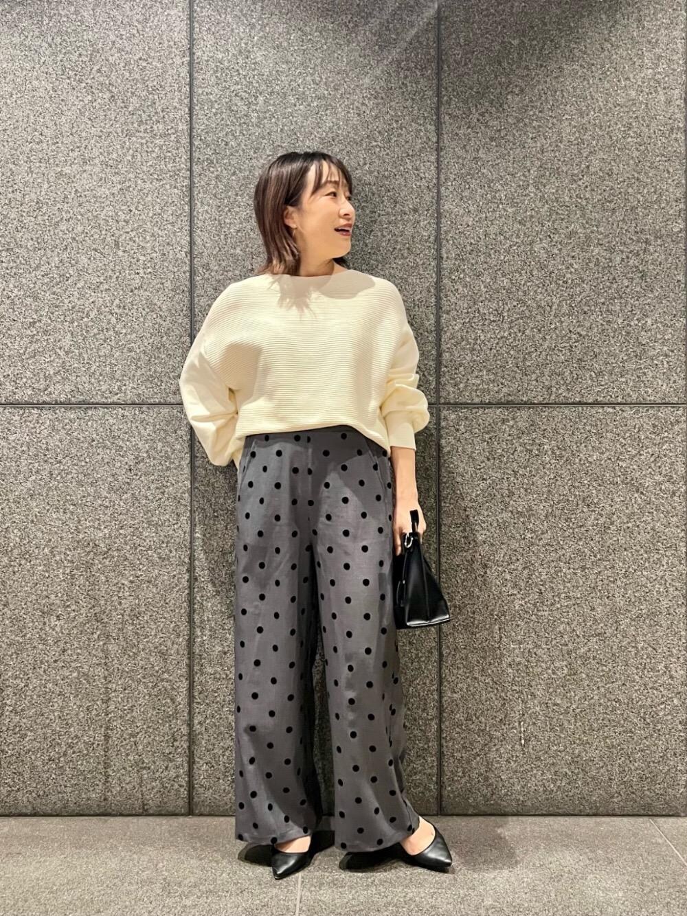 ホワイト系のニット/セーター、グレー系のその他パンツ、ブラック系のショルダーバッグを着用したレディースの冬コーディネートの1枚目の写真