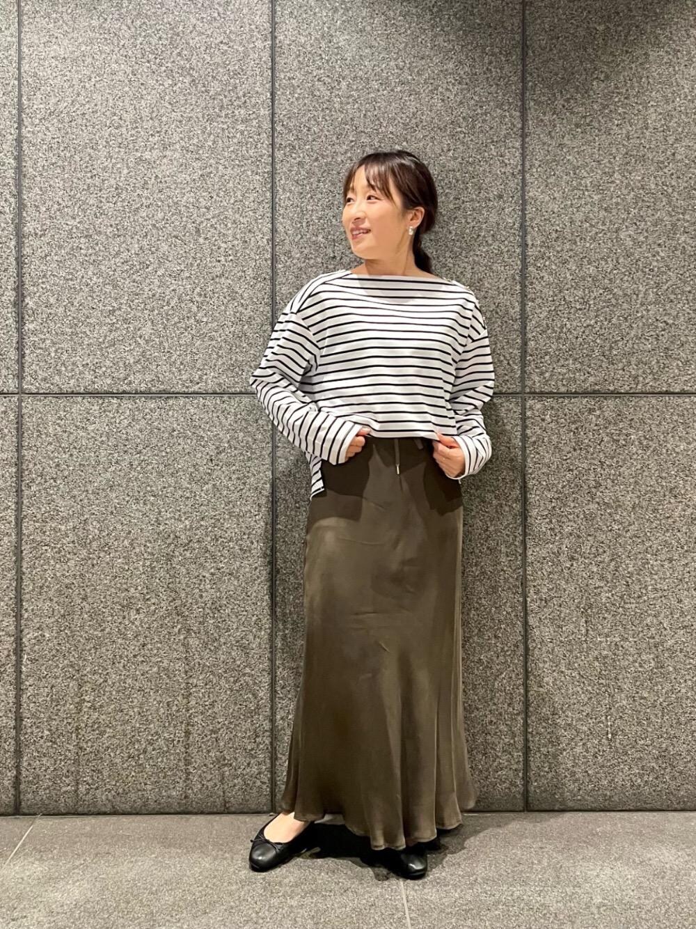 ブラウン系のスカート、ホワイト系のTシャツ/カットソーを着用したレディースの冬コーディネートの1枚目の写真
