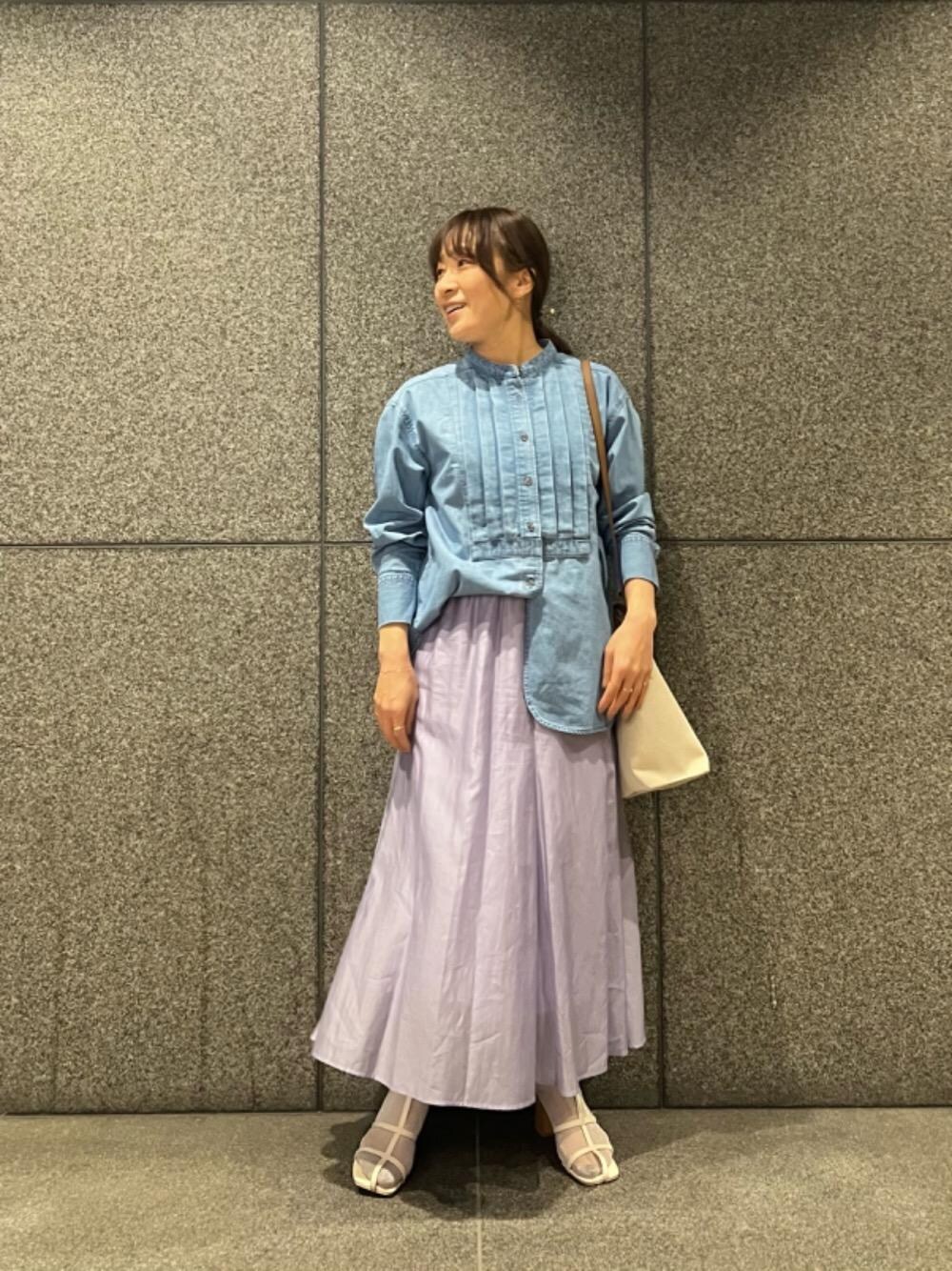 ブラウン系のショルダーバッグ、パープル系のスカート、ブルー系のシャツ/ブラウスを着用したレディースの春コーディネートの1枚目の写真