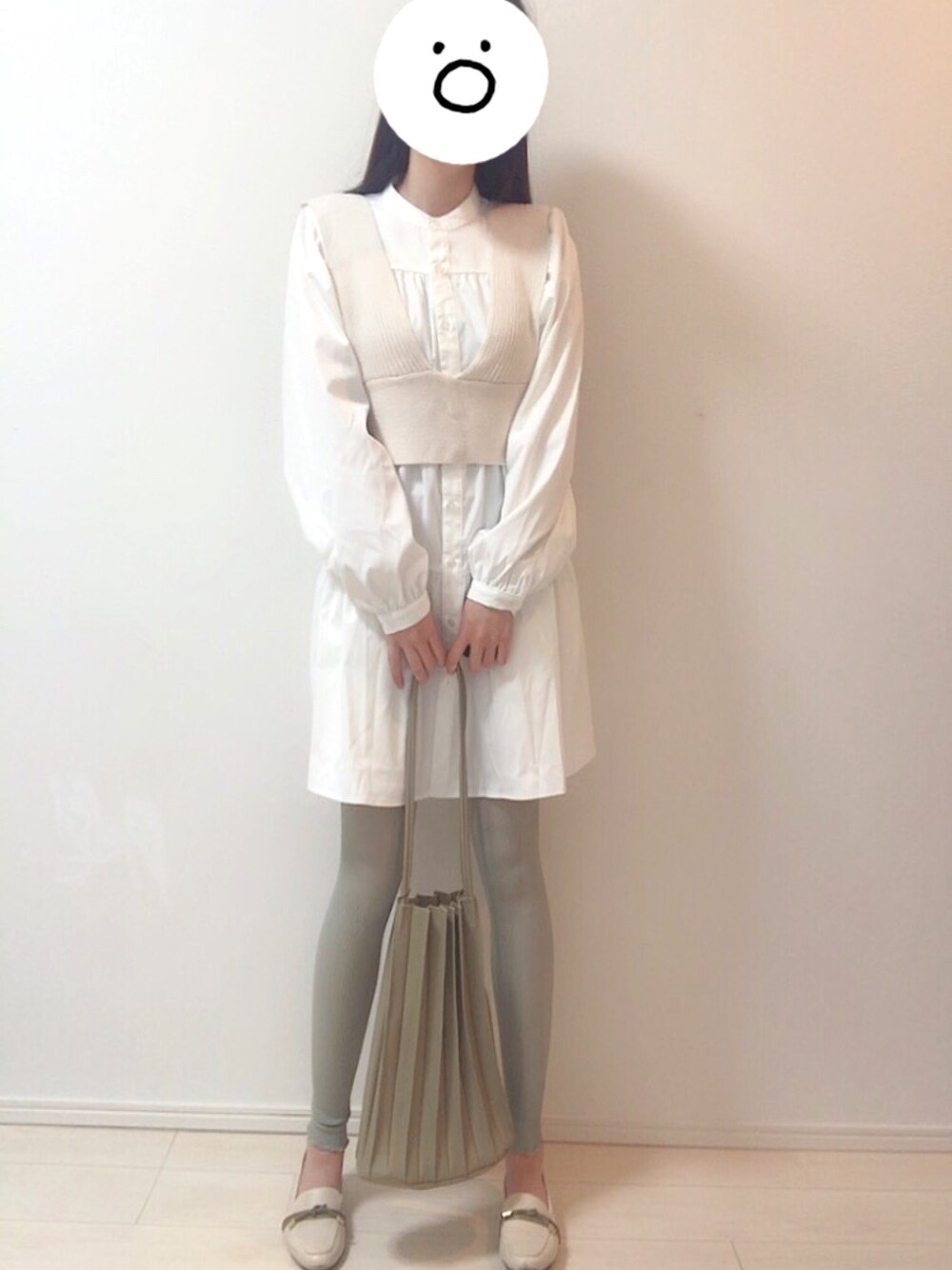 ホワイト系のベスト、ホワイト系のワンピースを着用したレディースの冬コーディネートの1枚目の写真