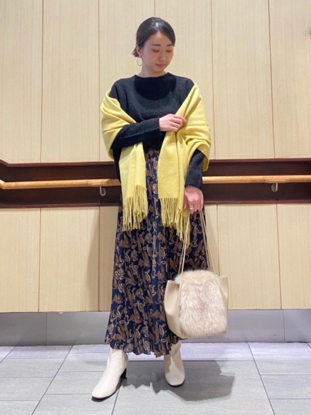 ブルー系のスカート、ブラック系のニット/セーター、ホワイト系のブーツを着用したレディースの秋コーディネートの1枚目の写真