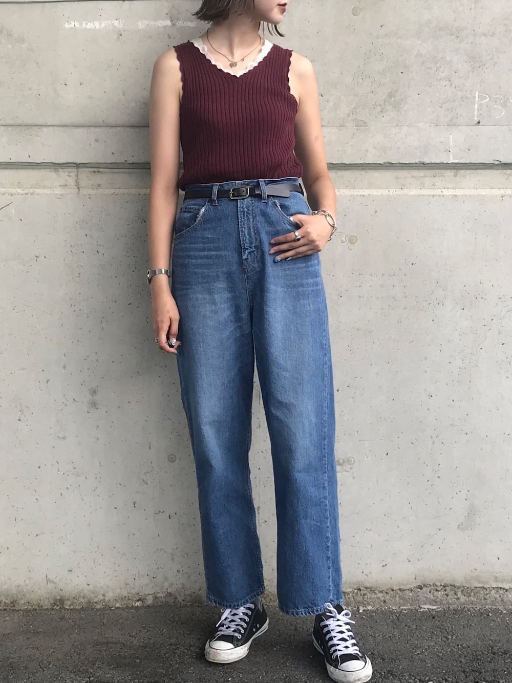 レッド系のタンクトップ、ブルー系のデニムパンツ、ブラック系のスニーカーを着用したレディースの夏コーディネートの1枚目の写真