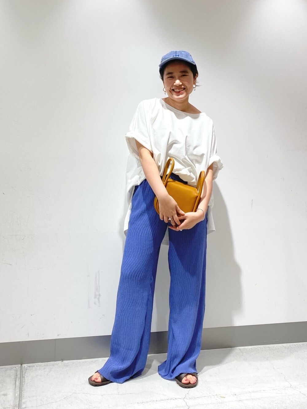 ホワイト系のTシャツ/カットソー、イエロー系のショルダーバッグ、ブルー系のその他パンツを着用したレディースの春コーディネートの1枚目の写真