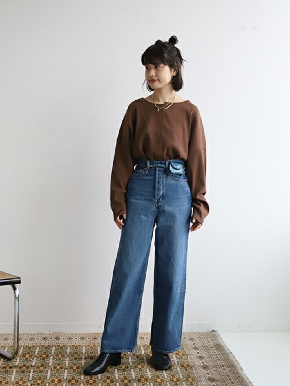 ブラウン系のTシャツ/カットソー、ブルー系のデニムパンツ、ブルー系のショルダーバッグを着用したレディースの秋コーディネートの1枚目の写真