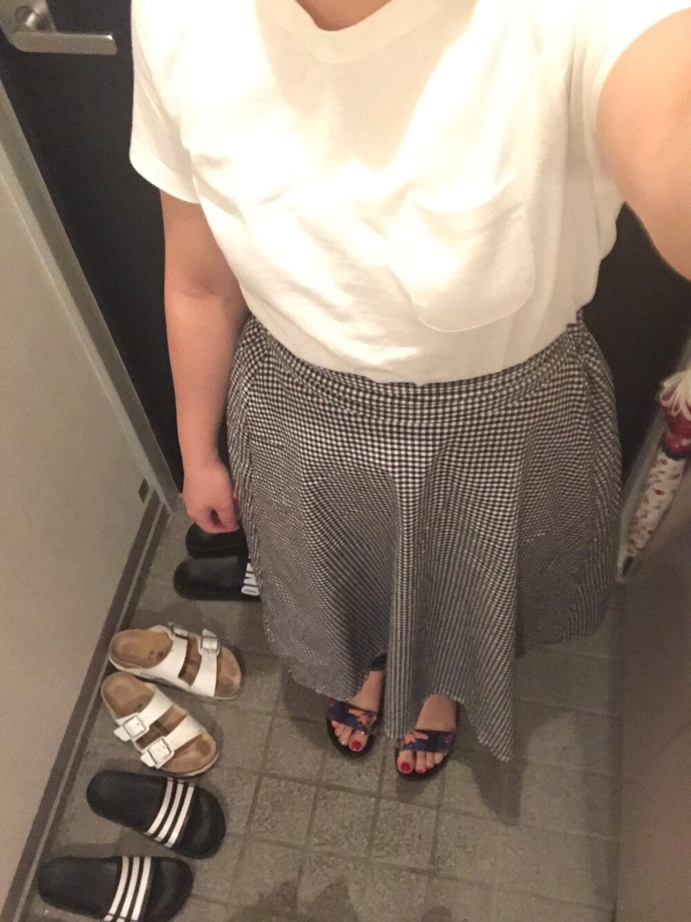 ホワイト系のTシャツ/カットソー、ブラック系のスカート、その他のサンダルを着用したレディースの夏コーディネートの1枚目の写真