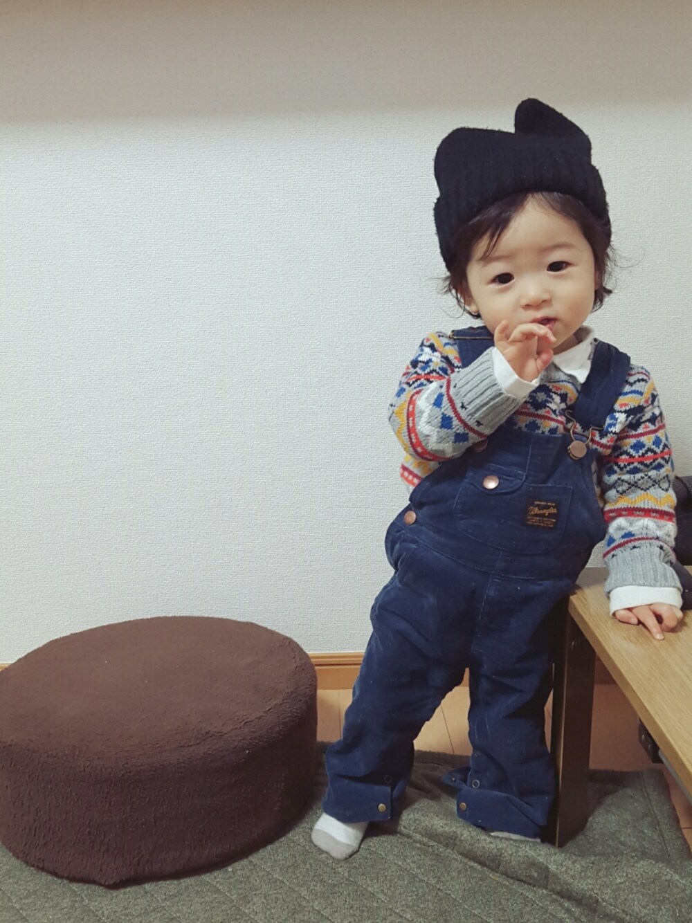 グレー系のニット/セーター、ブルー系のサロペット/オーバーオール、ブラック系の帽子を着用したキッズの冬コーディネートの1枚目の写真