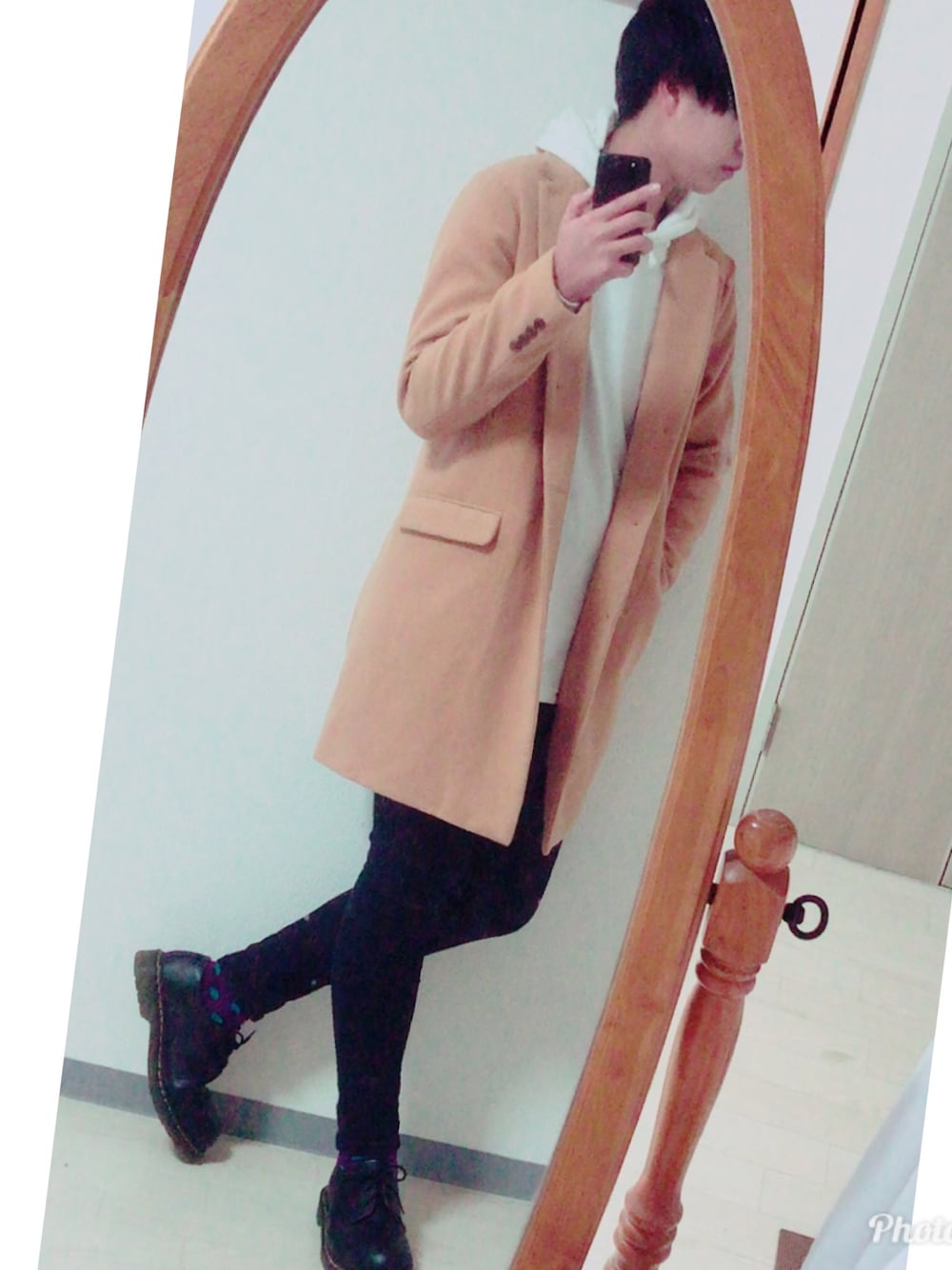 ブラウン系のチェスターコート、ホワイト系のパーカー、ブラック系のデニムパンツを着用したメンズの冬コーディネートの1枚目の写真