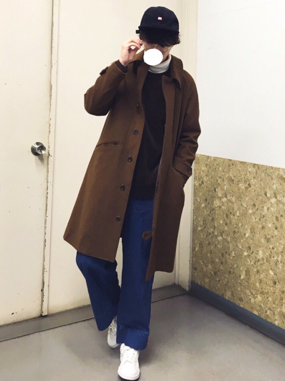 イエロー系のステンカラーコート、ブラウン系のスウェット、ホワイト系のTシャツ/カットソーを着用したメンズの冬コーディネートの1枚目の写真