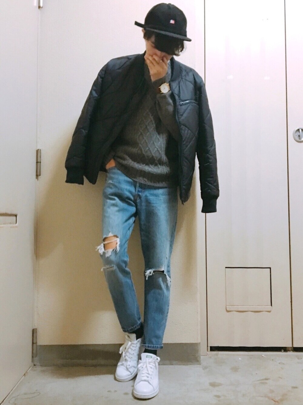 ブルー系のデニムパンツ、グレー系のニット/セーター、ホワイト系のスニーカーを着用したメンズの冬コーディネートの1枚目の写真