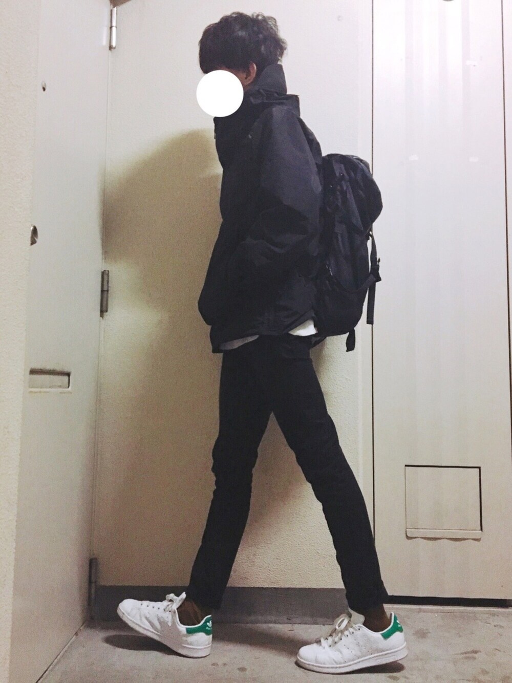 ブラック系のマウンテンパーカー、ブラック系のチノパンツ、ホワイト系のスニーカーを着用したメンズの春コーディネートの1枚目の写真