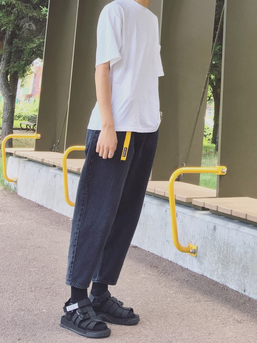 ホワイト系のTシャツ/カットソー、ブラック系のデニムパンツ、ブラック系のサンダルを着用したメンズの夏コーディネートの1枚目の写真