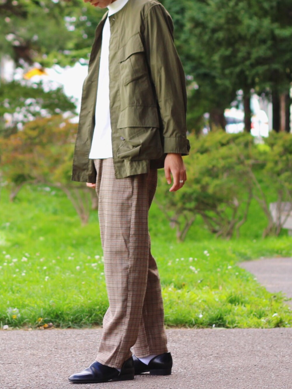 グリーン系のブルゾン、ホワイト系のTシャツ/カットソー、ベージュ系のその他パンツを着用したメンズの秋コーディネートの1枚目の写真