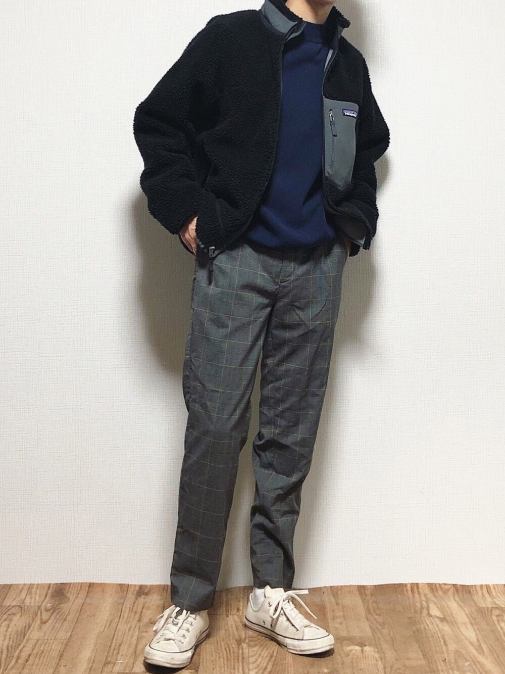 ブラック系のブルゾン、ブルー系のニット/セーター、グレー系のスラックスを着用したメンズの冬コーディネートの1枚目の写真