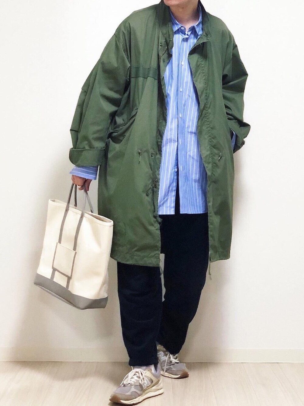 グリーン系のモッズコート、ブルー系のシャツ/ブラウス、ベージュ系のバッグを着用したメンズの春コーディネートの1枚目の写真