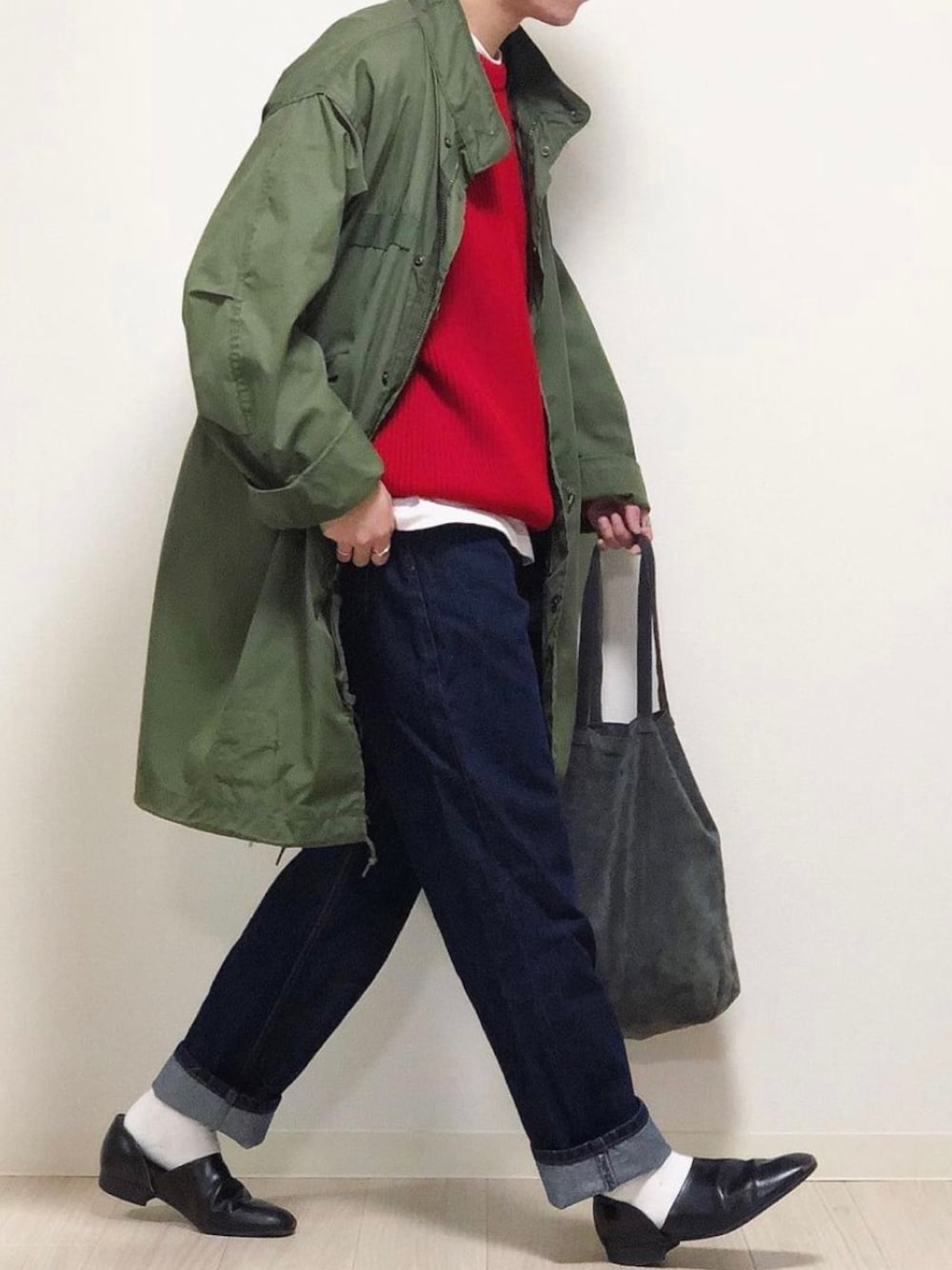 グリーン系のモッズコート、レッド系のニット/セーター、ブルー系のデニムパンツを着用したメンズの冬コーディネートの1枚目の写真