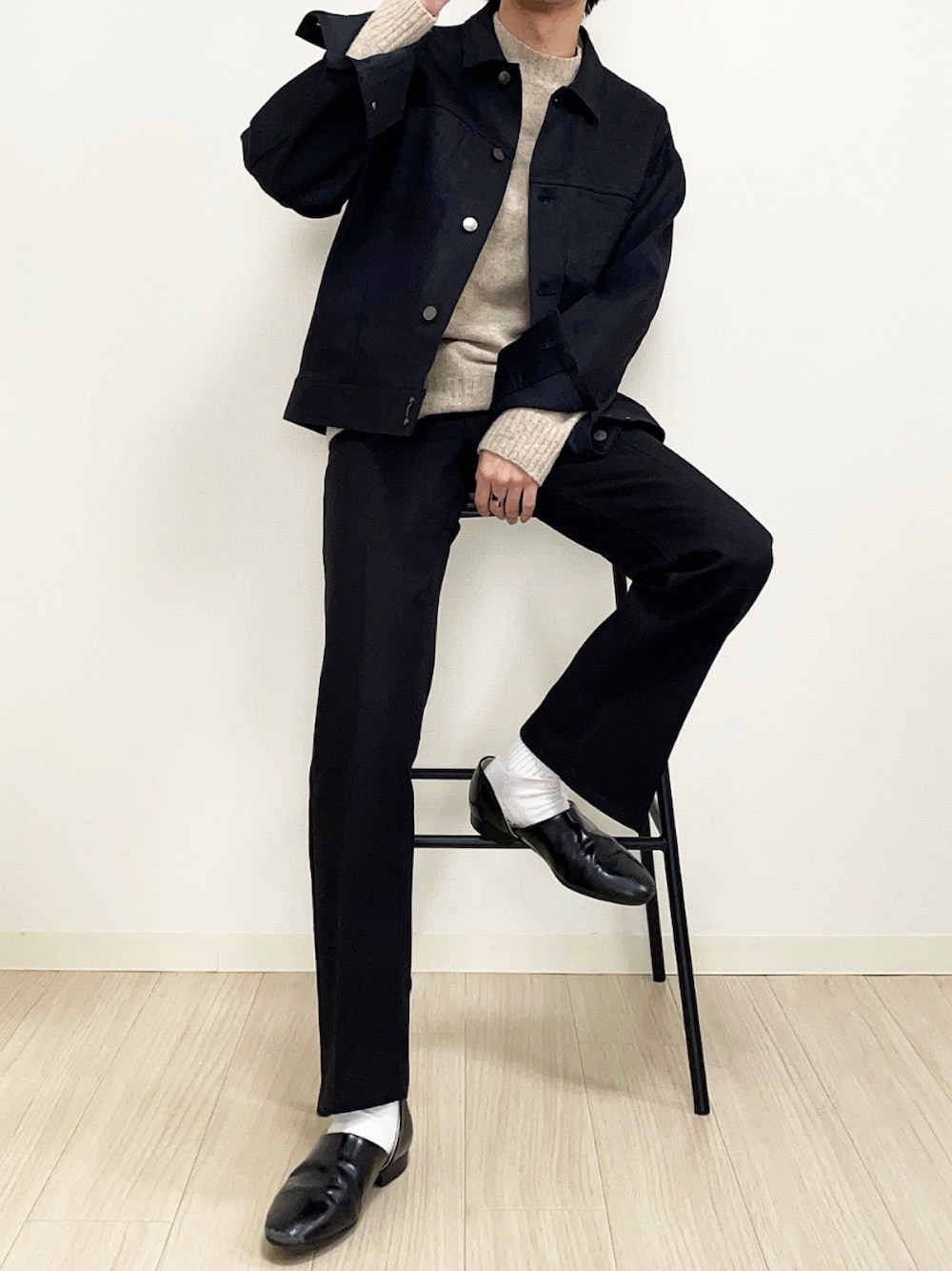 ブラック系のデニムジャケット、ベージュ系のニット/セーター、ブラック系のスラックスを着用したメンズの冬コーディネートの1枚目の写真